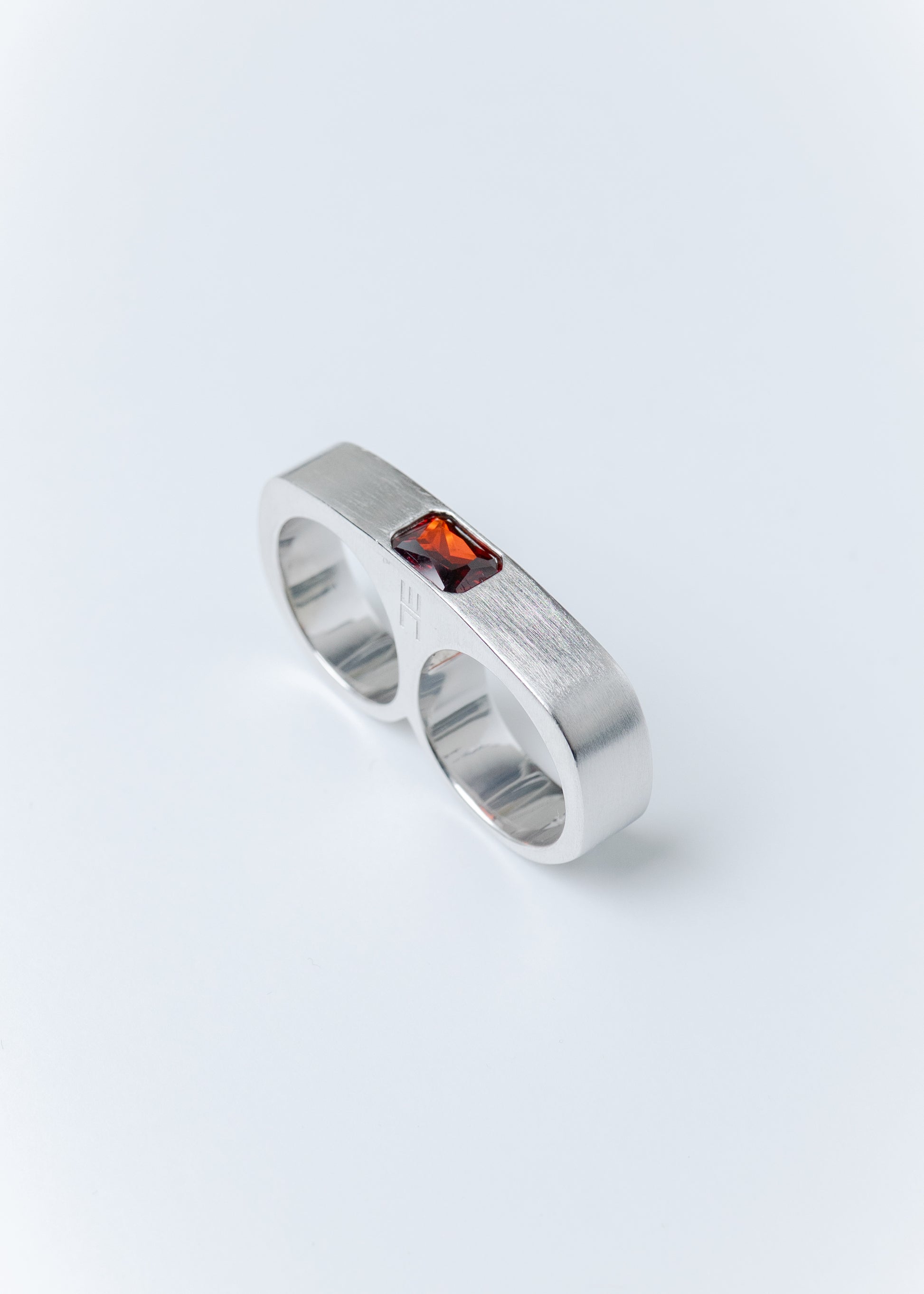 Maison Nwar sterling silver ring with red gemstone detail on light gray background