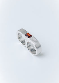 Maison Nwar sterling silver ring with red gemstone detail on light gray background