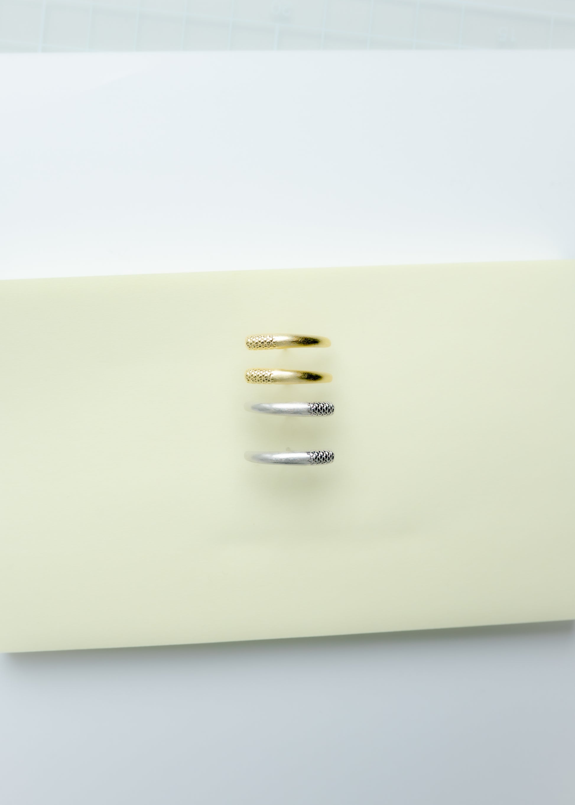 Maison Nwar curved gold vermeil stud earrings photographed on Maison Nwar packaging.