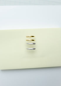 Maison Nwar curved gold vermeil stud earrings photographed on Maison Nwar packaging.