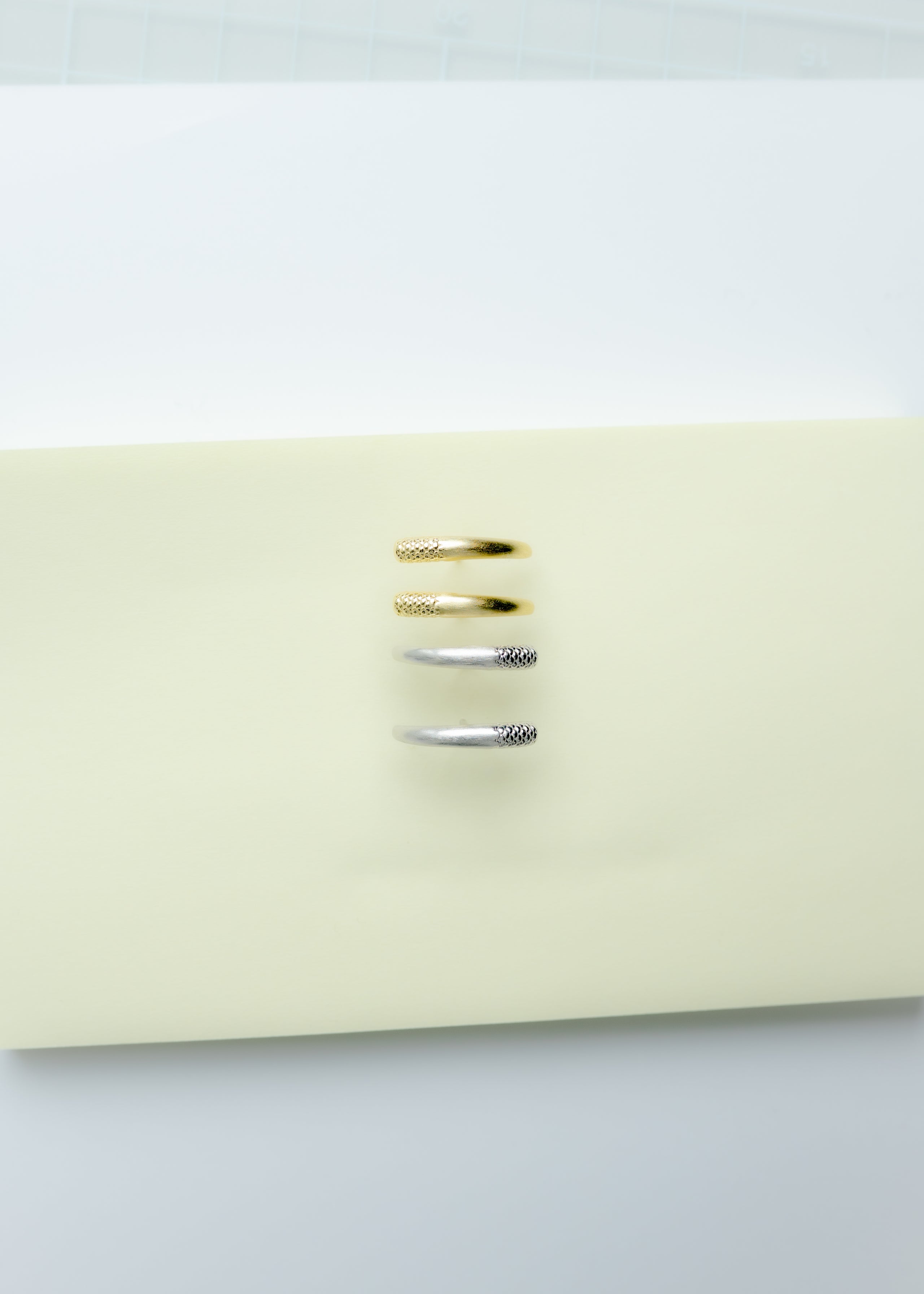 Maison Nwar curved gold vermeil stud earrings photographed on Maison Nwar packaging.