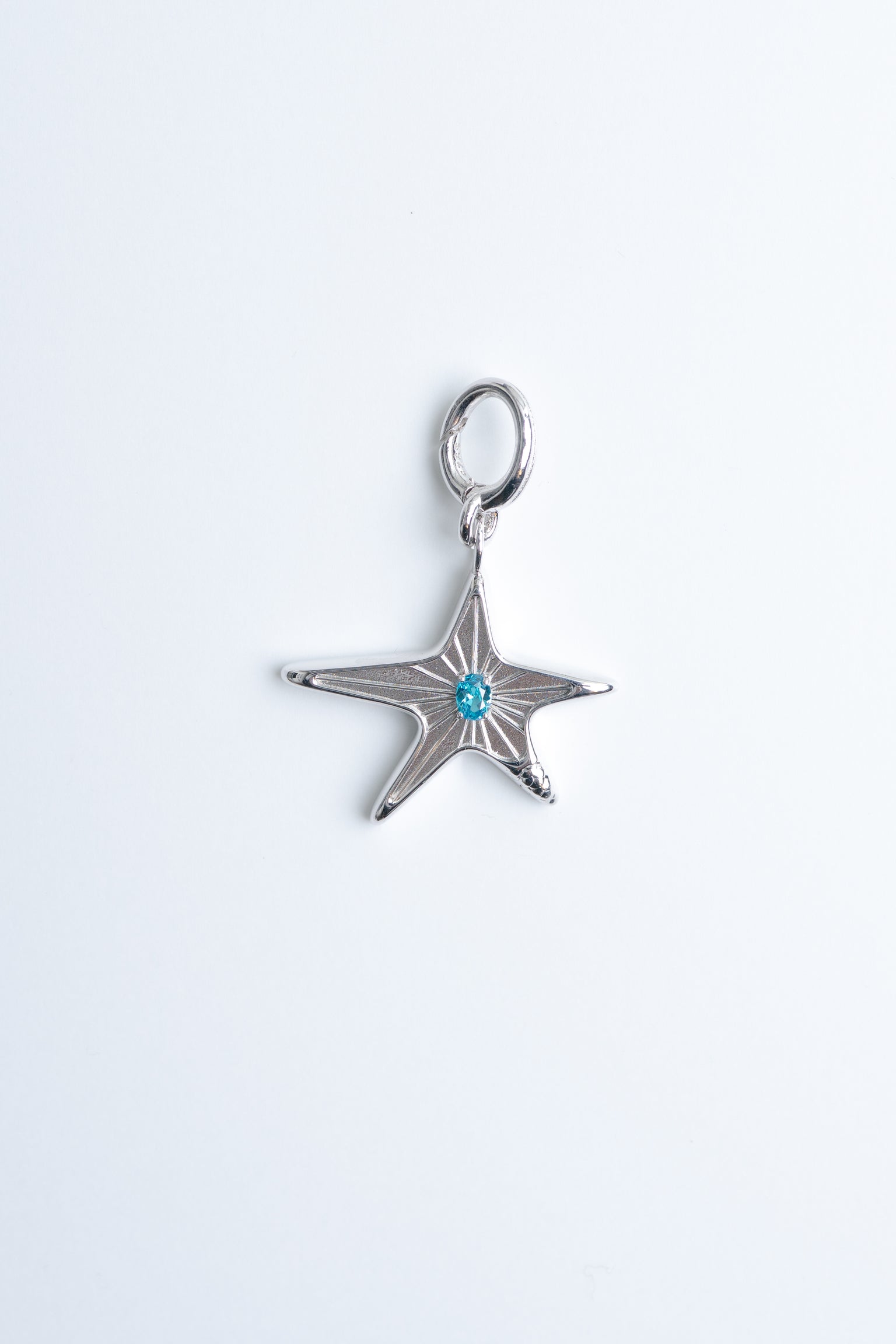 Maison Nwar star pendant in sterling silver with blue stone detail, studio shot on light background