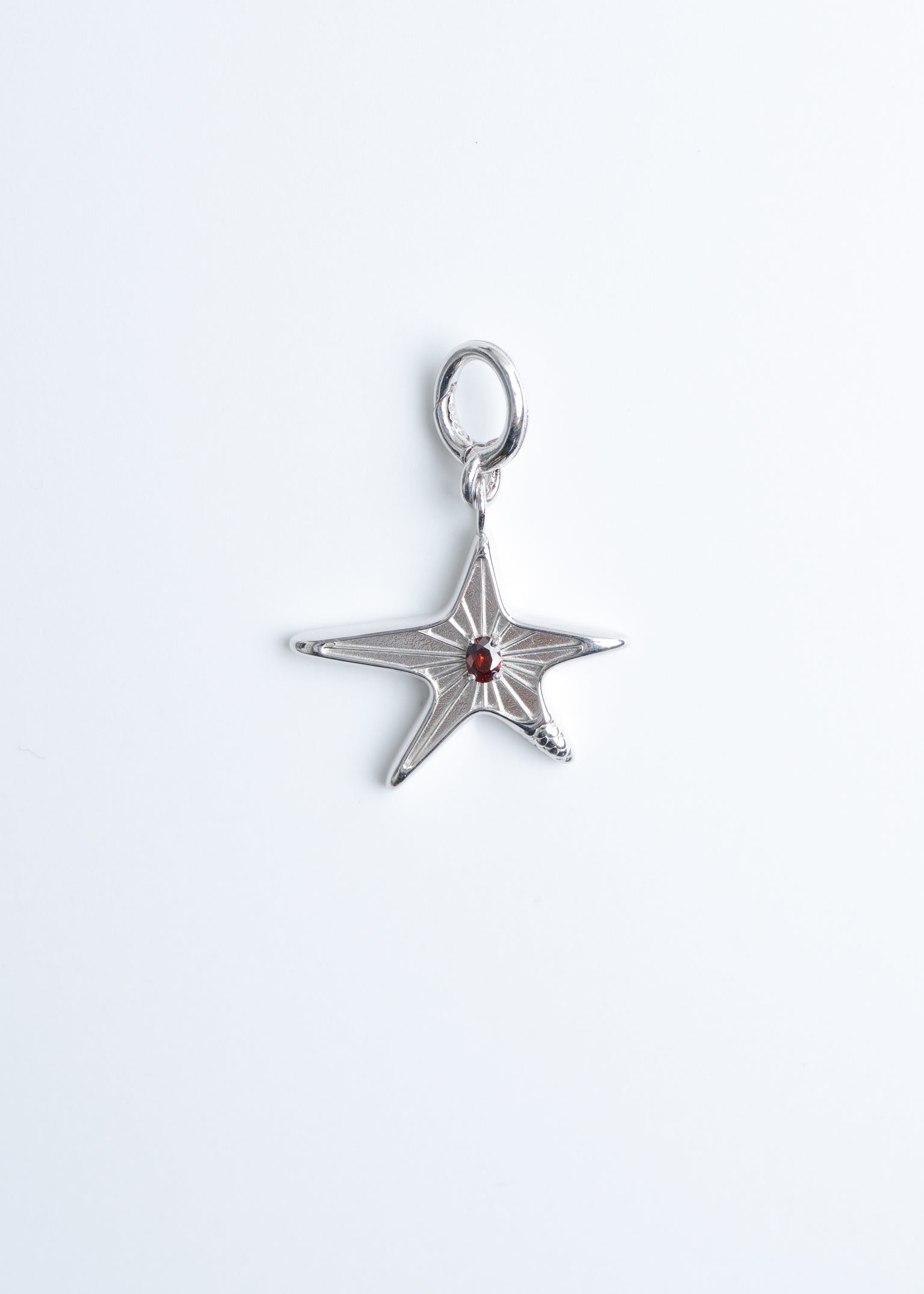 Maison Nwar star pendant in sterling silver on light grey background