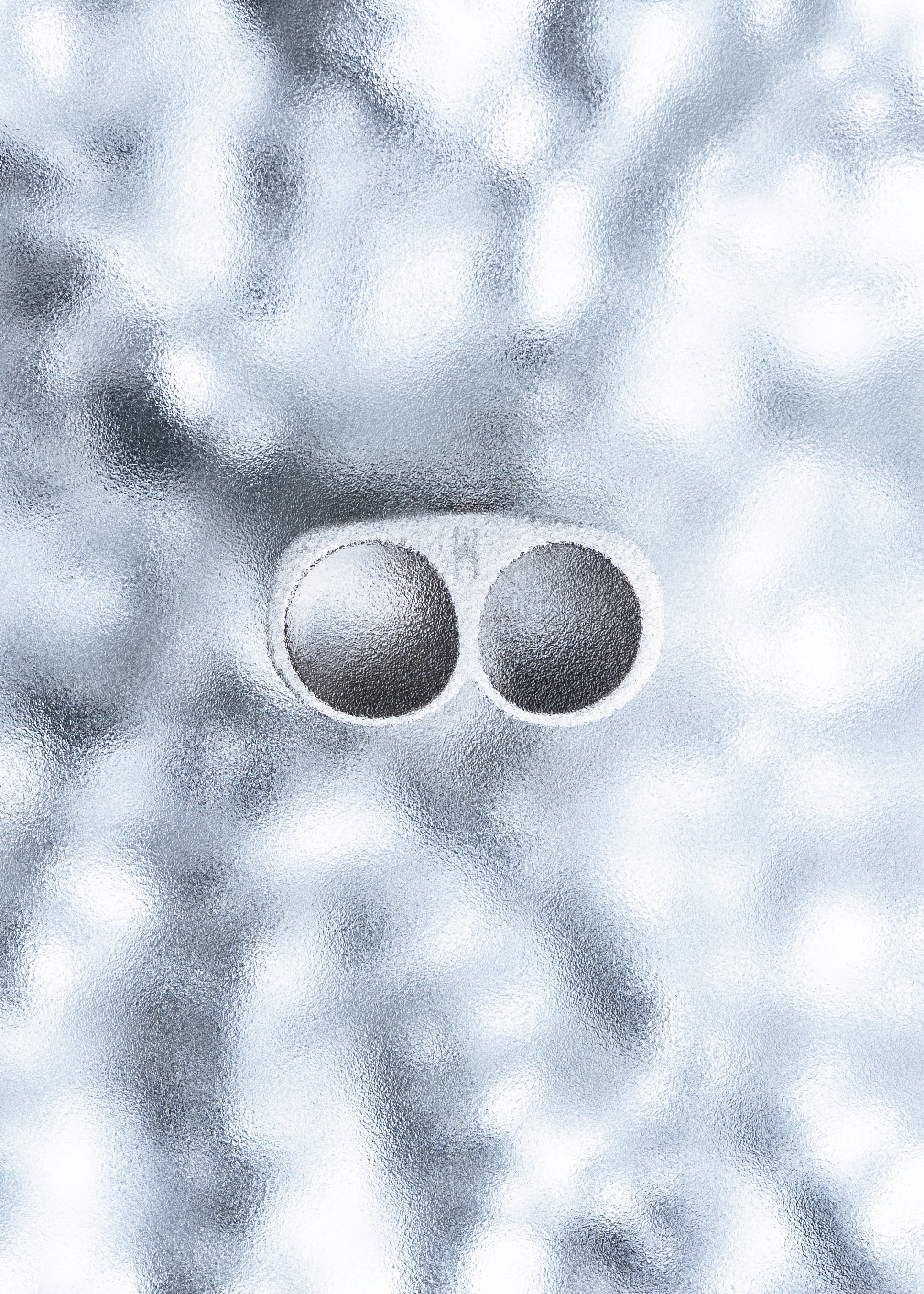 Two silver rings placed on a textured icy surface