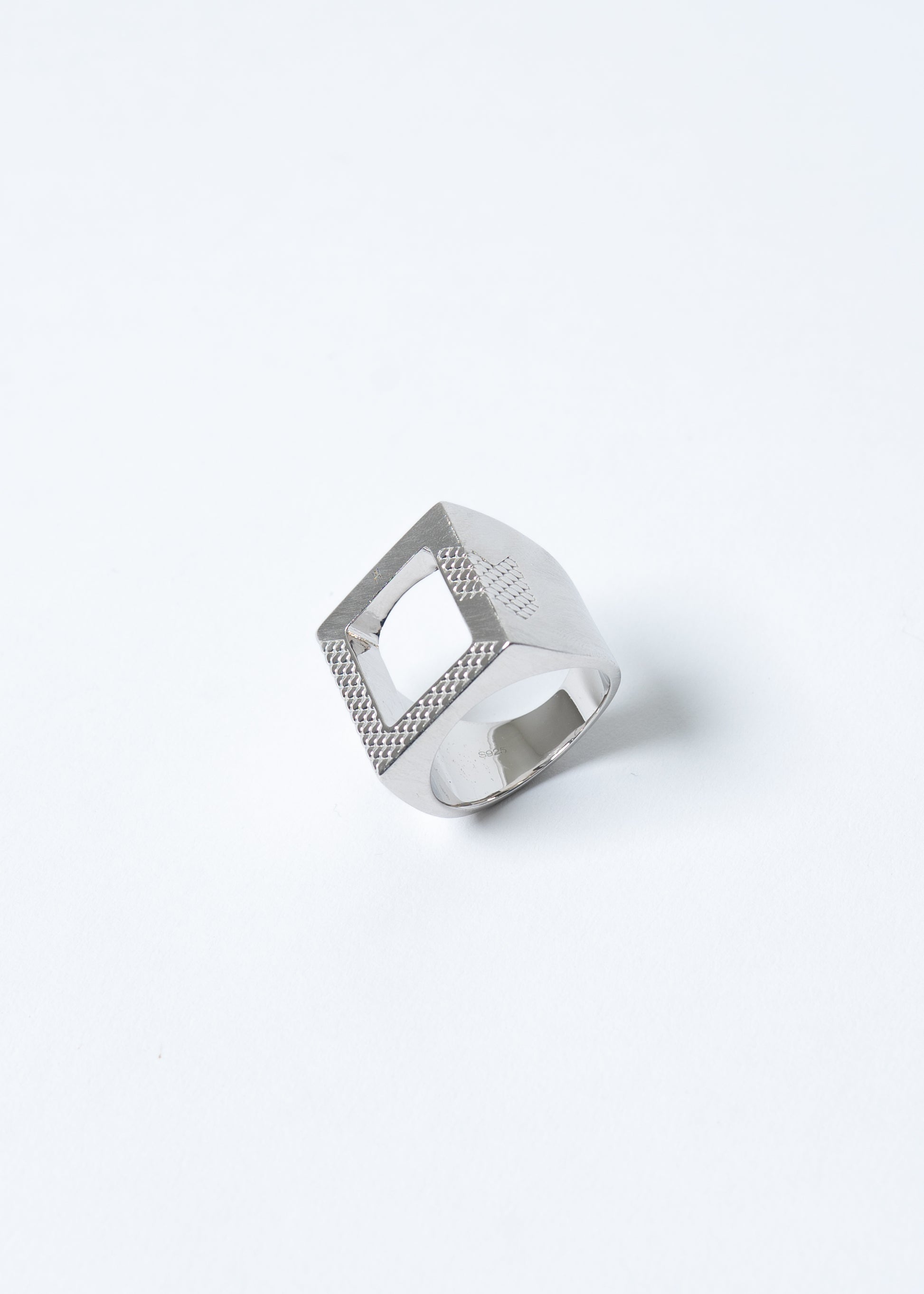 Maison Nwar ring on light grey background, sculptural square design