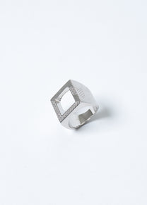 Maison Nwar ring on light grey background, sculptural square design