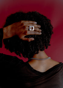 Model portrait wearing Maison Nwar ring, red styling detail
