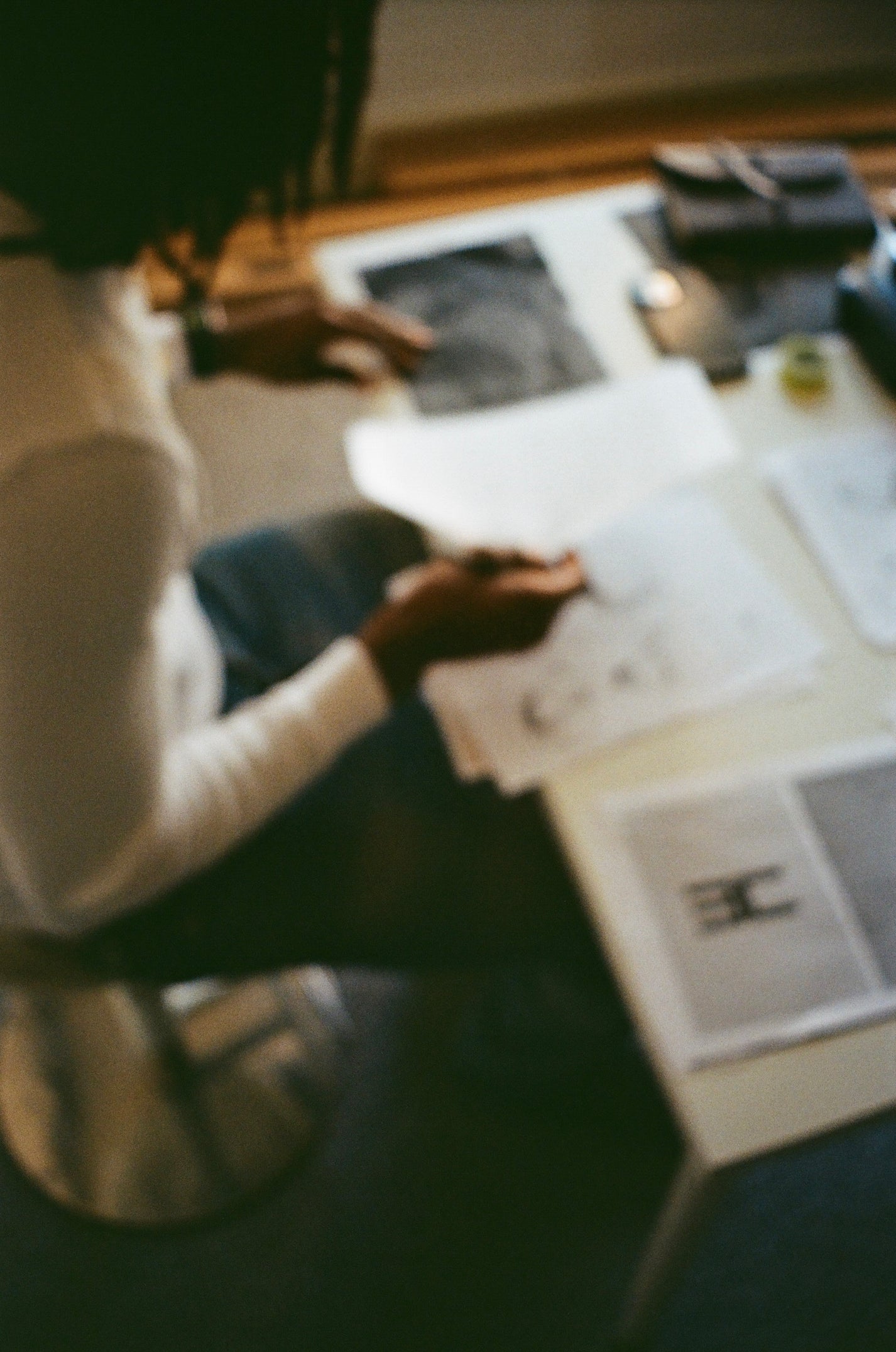 Person reviewing printed materials at a desk in a studio setting