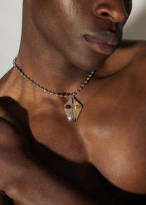 Model wearing Maison Nwar silver chain necklace — satin finish with bold red CZ accent