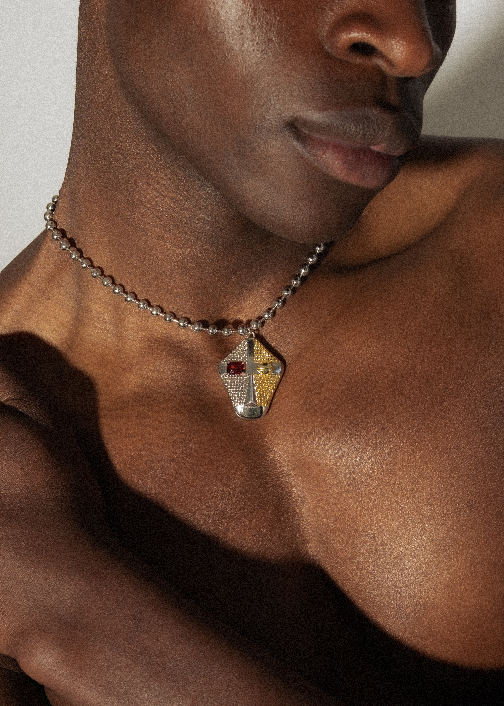 Model wearing Maison Nwar silver chain necklace — satin finish with bold red CZ accent